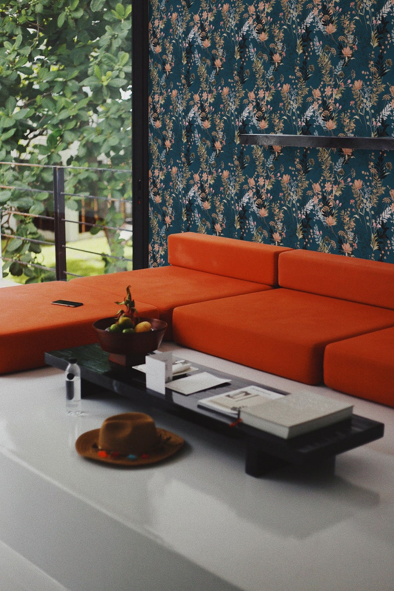 Teal Wildflowers peel and stick wallpaper covers a wall with scattered slender stems on deep teal, peach and gold accents.