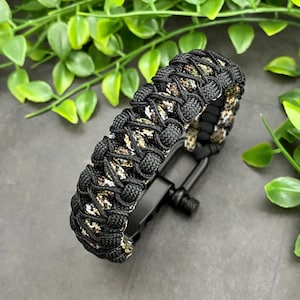 May include: Black and green camouflage paracord bracelet with a black metal clasp.