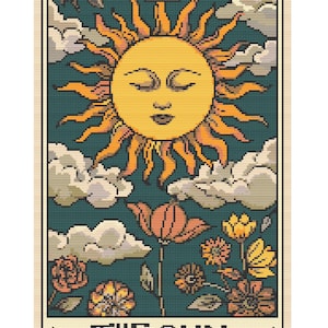 Puede incluir: Una carta de tarot de punto de cruz con un sol amarillo con ojos cerrados y rayos naranjas sobre un fondo verde azulado. La carta incluye el texto "THE SUN" en la parte inferior, con flores y nubes.