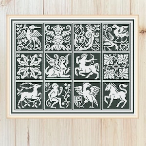 May include: Framed cross-stitch sampler with a grid of twelve black and white heraldic designs. Each square features a different mythical creature or decorative motif, in a light wood frame.