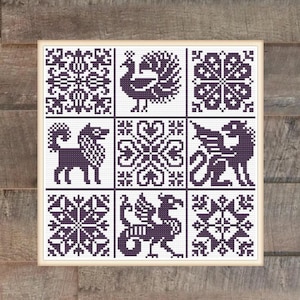 May include: A framed cross-stitch sampler with nine square panels. Each panel features a different dark purple design on a white background. The designs include geometric patterns, a peacock, and mythical creatures.
