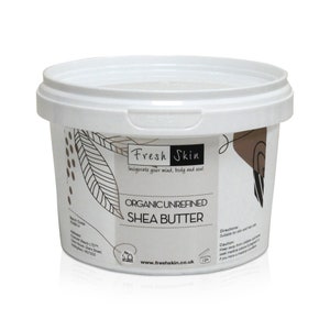 May include: A white plastic tub with a black and white label that says "Fresh Skin" and "Organic Unrefined Shea Butter". The label also includes the website address "www.freshskin.co.uk" and a 12M symbol.