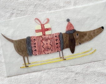 May include: A brown dachshund wearing a red and gray sweater with a white gift on its back is skiing on yellow skis.