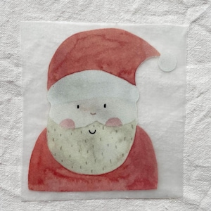 Pode incluir: Ilustração em aquarela do Papai Noel em um adesivo quadrado e transparente. O Papai Noel é retratado com um chapéu e casaco vermelhos, barba branca e bochechas rosadas. O adesivo é para artesanato ou decorações de Natal.