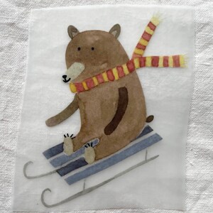 Pode incluir: Ilustração em aquarela de um urso marrom andando de trenó. O urso usa um cachecol listrado vermelho e amarelo e está sentado em um trenó azul e cinza. A imagem está em um fundo branco.