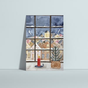Puede incluir: Una pintura de acuarela de una ventana con vista a un pueblo nevado de noche. Una vela encendida y un peque&ntilde;o &aacute;rbol de Navidad en maceta est&aacute;n en el alf&eacute;izar de la ventana.