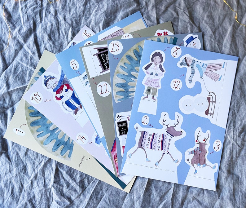 May include: A set of colorful paper cutouts featuring winter scenes and characters. The cutouts include a snowman, reindeer, a person wearing a winter coat, and a person wearing a red and white striped sweater. The cutouts are numbered 1 through 12.
