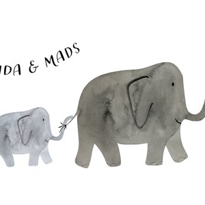 May include: Watercolor illustration of two gray elephants, a larger one and a smaller one, walking together. The smaller elephant holds the tail of the larger one. The text "IDA & MADS" is at the top. Green leaves and a yellow flower are on the right.