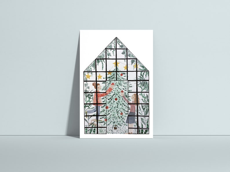 Puede incluir: Dos personas decoran un &aacute;rbol de Navidad dentro de un invernadero. El &aacute;rbol es verde con adornos rojos y estrellas amarillas. El invernadero est&aacute; hecho de metal negro y vidrio.