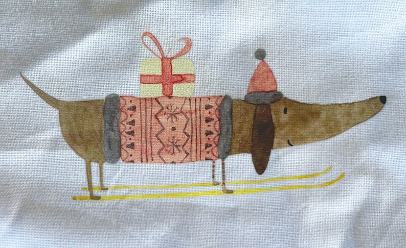 May include: A brown dachshund wearing a pink and gray sweater and a red Santa hat is carrying a wrapped gift on its back. The dachshund is standing on yellow skis on a white background.