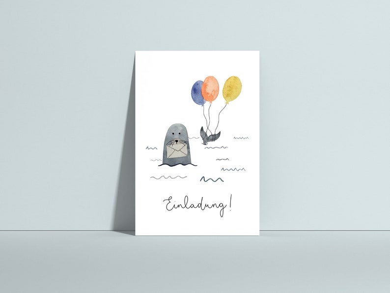 May include: A watercolor illustration on a white card features a gray seal holding a letter, with three balloons in orange, blue, and yellow. The word "Einladung!" is written in cursive below the seal. The image has a whimsical, playful style.