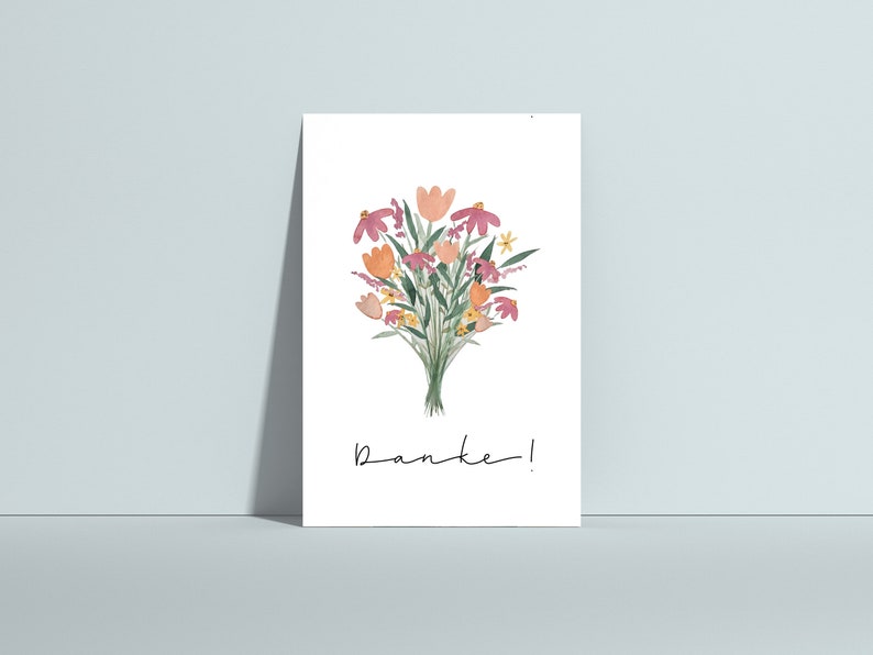 May include: A white card with a watercolor illustration of a bouquet of pink, orange, and yellow flowers. The text "Danke!" is written in black cursive at the bottom of the card.