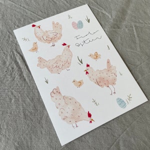 Pu&ograve; includere: Un biglietto bianco con un'illustrazione ad acquerello di galline e pulcini. Il biglietto ha il testo "Frohe Ostern" scritto su di esso, che in tedesco significa "Buona Pasqua".