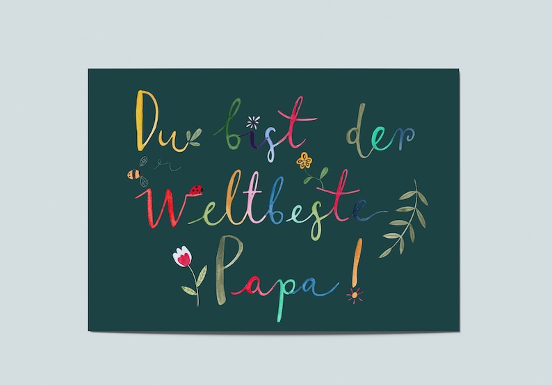 May include: A green card with the text "Du bist der weltbeste Papa!" in colorful script. The text is surrounded by small flowers, leaves, and insects.