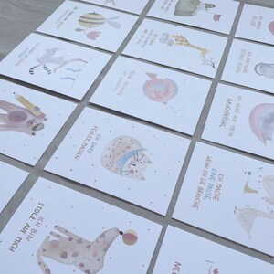Op de afbeelding: Een set van 10 ge&iuml;llustreerde kaarten met aquareldieren en motiverende zinnen in het Duits. De kaarten tonen verschillende dieren, waaronder een kat, een hond, een vis, een bij, een giraffe en een gans. Elke kaart heeft een andere zin, zoals "Ich darf Fehler machen" (Ik mag fouten maken) en "Ich bin stolz auf mich" (Ik ben trots op mezelf).