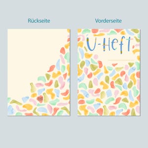 May include: A colorful notebook cover with a light yellow background and a pattern of abstract shapes in shades of pink, blue, green, and orange. The front cover has the text "U-Heft" in blue and yellow.