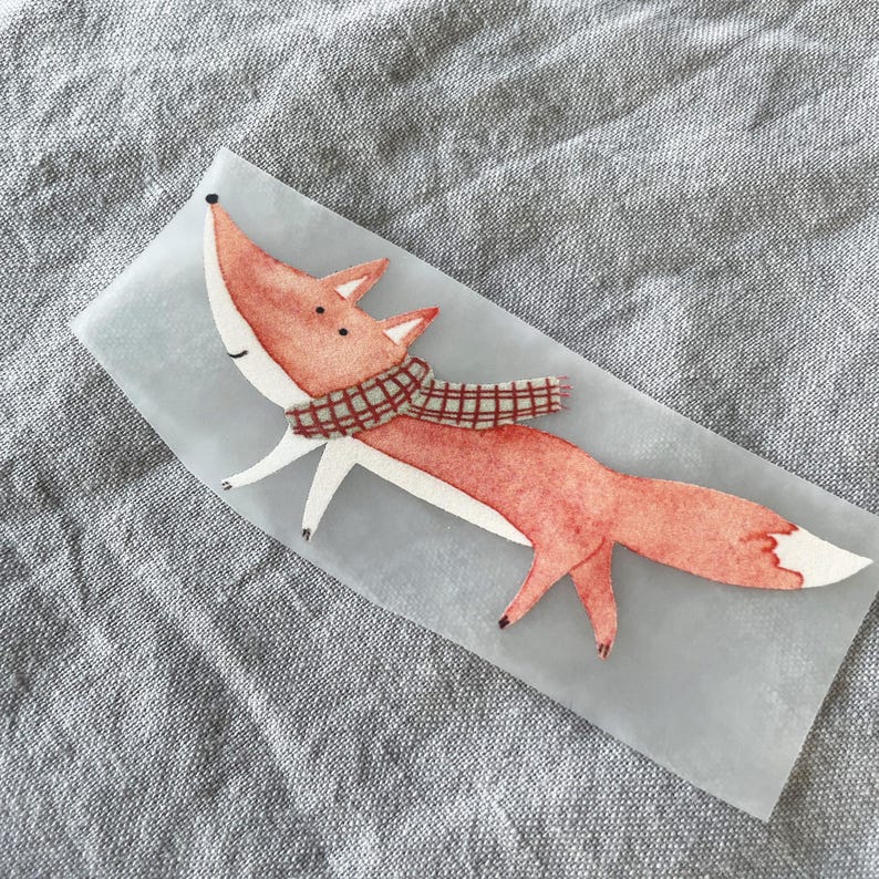May include: A red fox with a plaid scarf is illustrated on a white background. The fox is walking with its tail curled up behind it.