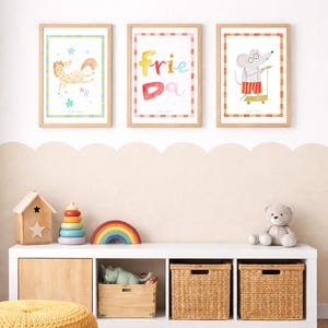 May include: Three framed watercolor prints with animal illustrations and the word "Friend" in colorful letters. Below, a white shelf holds toys, including a wooden house, a rainbow, and a teddy bear. A yellow pouf and a patterned rug complete the scene.
