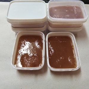 May include: Four white plastic containers with lids, two filled with a brown liquid, and two empty.