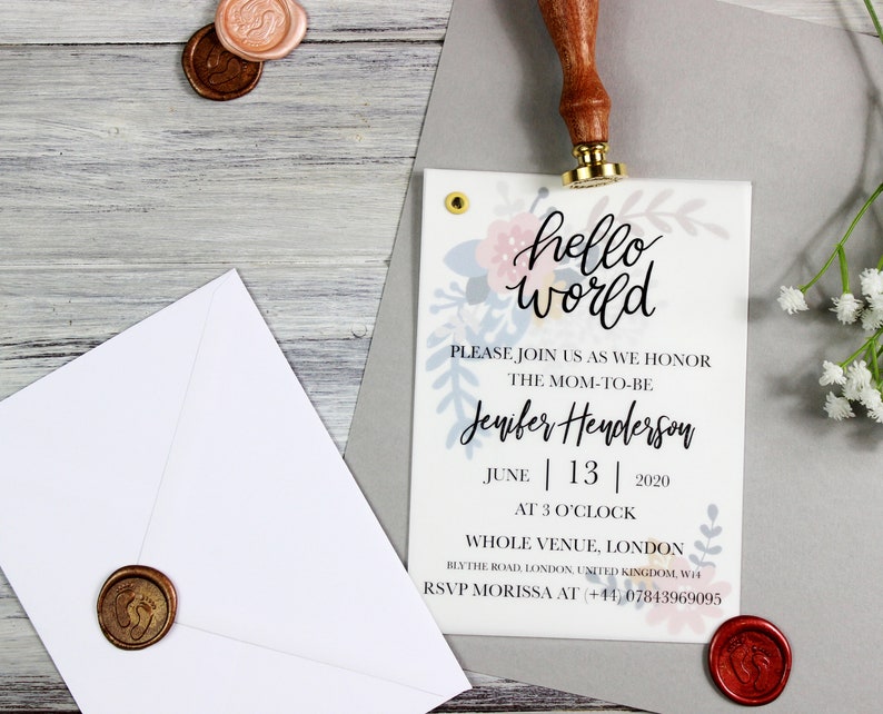 Op de afbeelding: Een babyshower-uitnodiging met een bloemenontwerp en de tekst "hello world". De uitnodiging is voor Jenifer Henderson en staat gepland voor 13 juni 2020 om 15:00 uur. De locatie is Whole Venue, Londen, Blythe Road, Londen, Verenigd Koninkrijk, WH. Het RSVP-nummer is +41 07843969095.