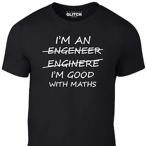 Op de afbeelding: Zwart T-shirt met witte tekst die "Ik ben een ingenieur Ik ben goed in wiskunde" luidt, met het woord "ingenieur" doorgestreept.