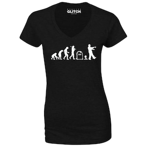 May include: Black V-neck t-shirt with a white graphic of the evolution of man ending with a zombie. The graphic includes the text "RIP".