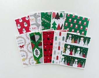 May include: A set of ten Christmas-themed gift tags with various designs. The tags feature red, green, white, and black colors. Some designs include snowmen, Christmas trees, ornaments, and reindeer. The text on the tags includes "Merry & Bright", "Let It Snow", "Merry Christmas", and "Happy Holidays".