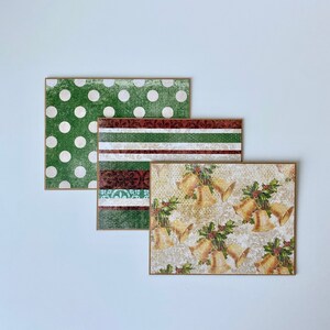 May include: Three Christmas card designs. The first card has a green background with white polka dots. The second card has a green, white, and red striped pattern. The third card has a cream background with a gold bell pattern.