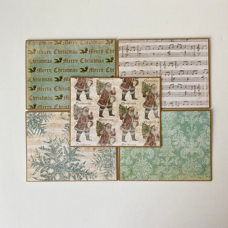 May include: Set of six vintage-style Christmas cards featuring a variety of designs. The cards are printed on textured paper with a green and white color scheme. One card features a repeating pattern of Santa Claus holding a Christmas tree and a drum. Another card features a repeating pattern of the words "Christmas" and "Merry Christmas". Another card features a repeating pattern of musical notes. The remaining cards feature a variety of Christmas-themed designs.