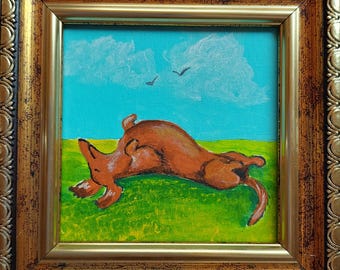May include: A framed painting depicts a brown dog rolling on its back in a green field under a blue sky with white clouds and two birds. The painting is in a gold ornate frame.