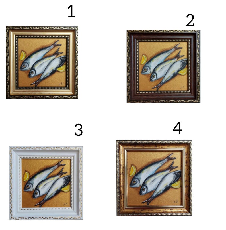 May include: Four square framed paintings featuring a still life of three silver fish and two yellow lemon wedges on a textured gold background. Each frame has a distinct finish: metallic gold, dark brown, white, and an antique gold tone.