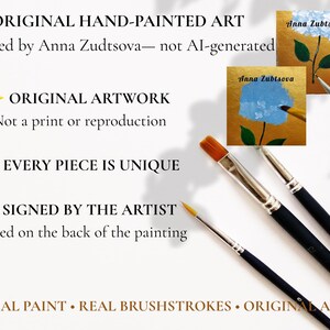May include: Three black-handled paintbrushes with silver ferrules and synthetic bristles are positioned near two small square paintings of blue hydrangea flowers on gold backgrounds, featuring the artist's signature Anna Zubtsova.