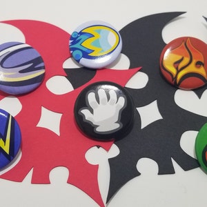 May include: Six round buttons with different designs. The buttons are arranged in a circle on a red and black background. The designs include a hand, a flame, a can, a lightning bolt, a galaxy, and a wave.