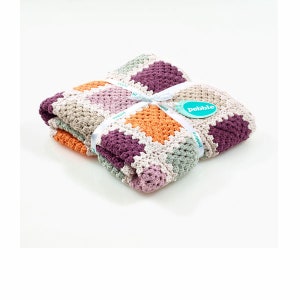 Peut inclure: Une couverture pour b&eacute;b&eacute; en crochet multicolore avec un ruban blanc et une &eacute;tiquette indiquant "Pebble".