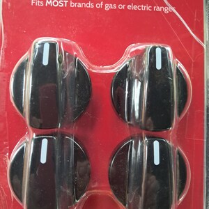 May include: Four black universal range knobs in a clear plastic package. Each knob has a white indicator line. The packaging is red with white text that reads "Universal Range Knobs" and "Fits MOST brands of gas or electric ranges."