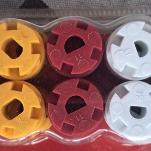 May include: A set of ten multi-colored plastic coupling connectors in a clear plastic package. The connectors are green, yellow, red, white, and blue. Each connector has a central hole and is marked with a number.