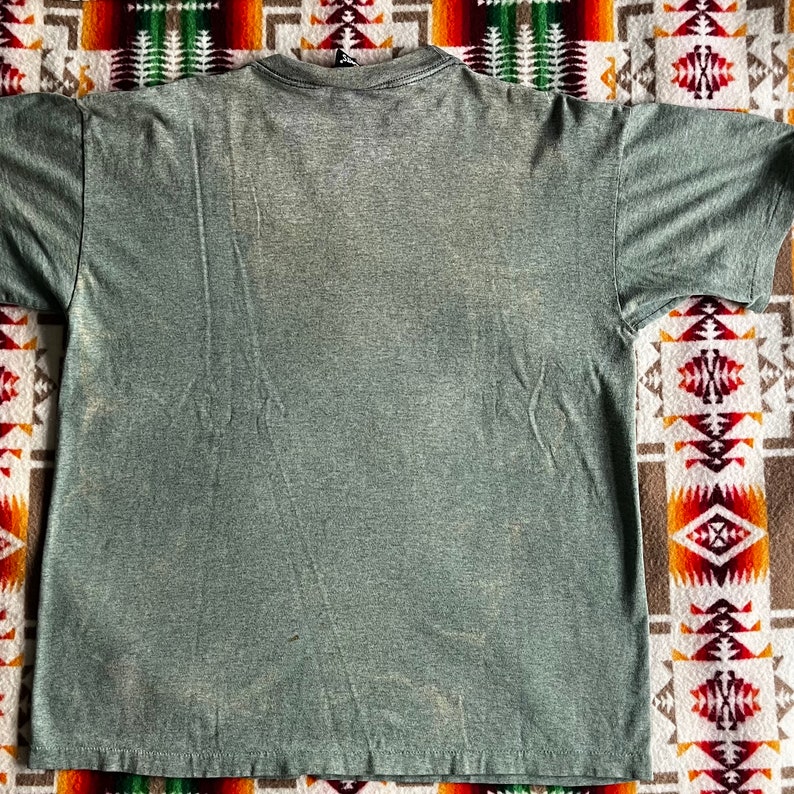 May include: A green heather t-shirt with a crew neck and short sleeves.