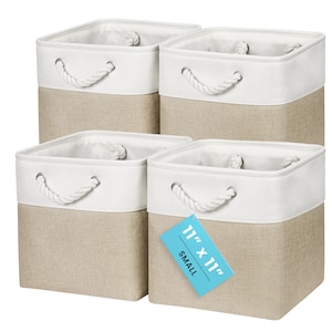 May include: A set of four square storage bins featuring a two-tone design with a tan lower section and a white upper band. Each bin includes white rope handles attached with silver metal grommets. A blue tag on one bin reads 11" x 11" SMALL.