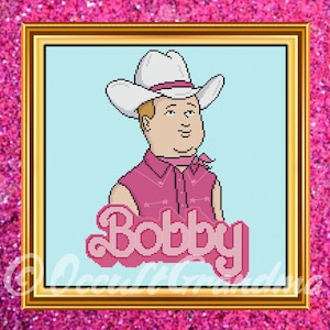 May include: Cross-stitch portrait of a cartoon character wearing a white cowboy hat, pink shirt, and a pink neckerchief. The name "Bobby" is displayed in pink cursive letters. The artwork is framed in gold against a pink glitter background.