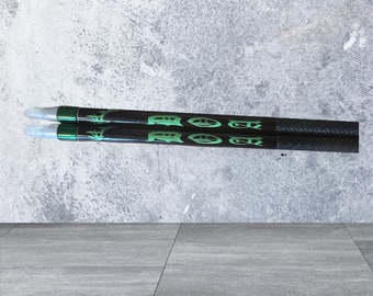 May include: Two black carbon arrows with green lettering that reads "ROCKET" on each arrow.