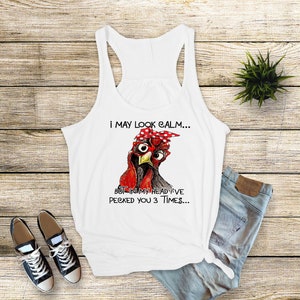 May include: White tank top with a black and red illustration of a chicken wearing a red bandana with white polka dots. The text on the tank top reads "I may look calm... But in my head I've pecked you 3 times..."