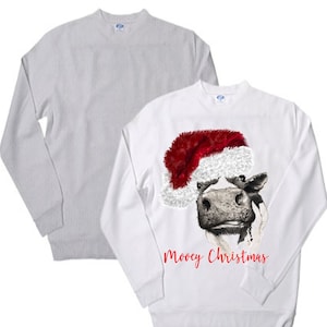 Peut inclure: Sweat-shirts à manches longues blancs et gris. Le sweat-shirt blanc présente une vache noire et blanche portant un bonnet de Père Noël rouge avec le texte "Mooey Christmas".