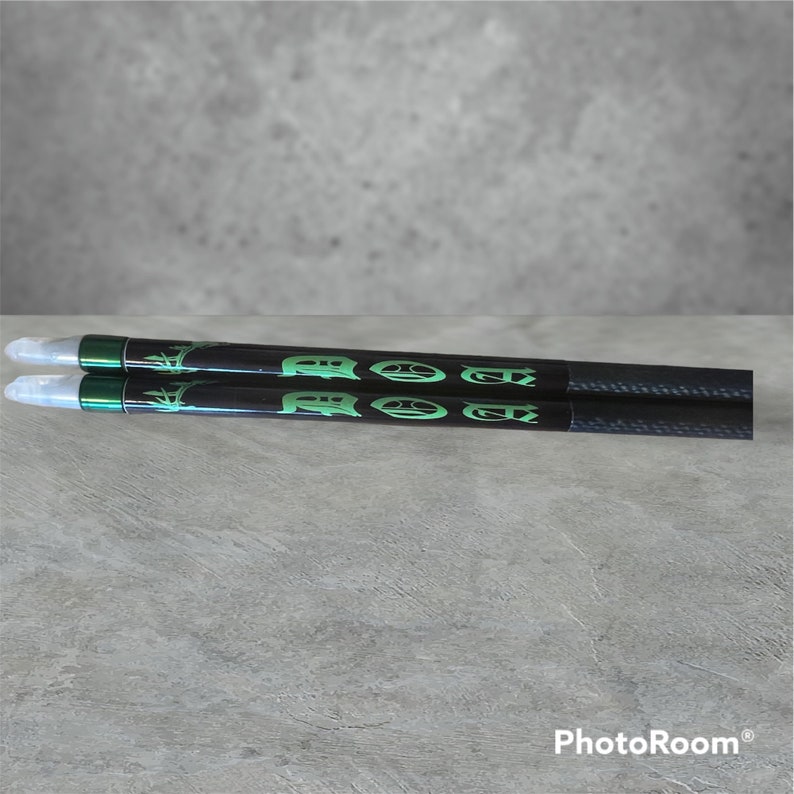 K&ouml;nnte beinhalten: Zwei schwarze Drumsticks mit gr&uuml;nen Akzenten und dem aufgedruckten Wort "RODZ".