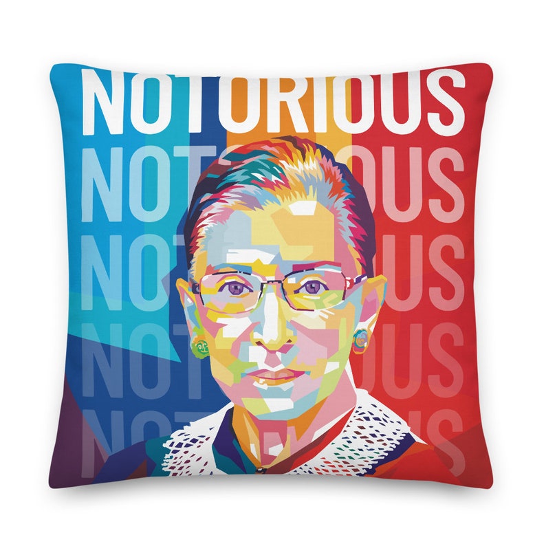 May include: A colorful pop art style illustration of Ruth Bader Ginsburg with the word "NOTORIOUS" repeated in the background. The background is a mix of red, blue, and yellow.