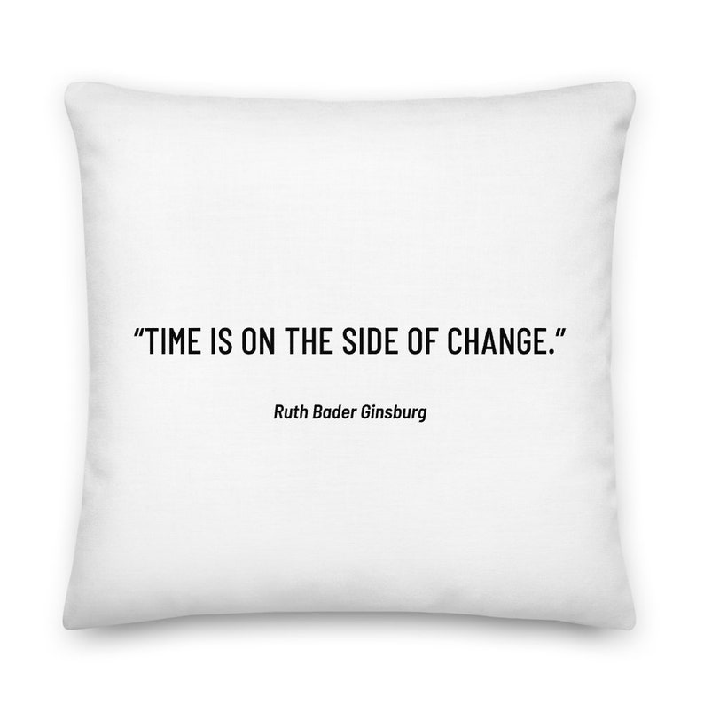 May include: White throw pillow with the quote "TIME IS ON THE SIDE OF CHANGE." by Ruth Bader Ginsburg.