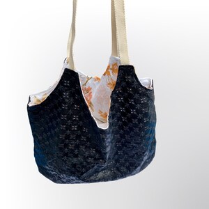 Bolsa reversível em couro sintético, lisa, preta ou com estampa floral