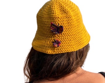 Crocheted sun or winter hat in a sunny yellow decorated with butterflies