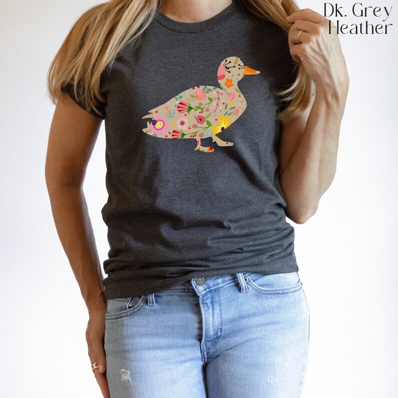 Peut inclure: Un t-shirt gris chin&eacute; fonc&eacute; avec un motif de canard floral. Le canard est d&eacute;limit&eacute; par un contour noir et rempli de fleurs color&eacute;es.