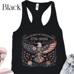 May include: Black tank top with a patriotic design. The graphic features an eagle with wings in red, white, and blue, surrounded by floral elements. Text reads "250 YEARS OF FREEDOM 1776-2026".