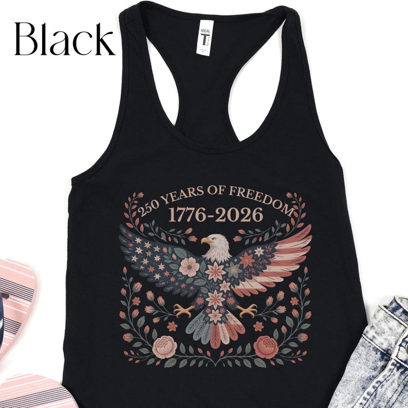 May include: Black tank top with a patriotic design. The graphic features an eagle with wings in red, white, and blue, surrounded by floral elements. Text reads "250 YEARS OF FREEDOM 1776-2026".